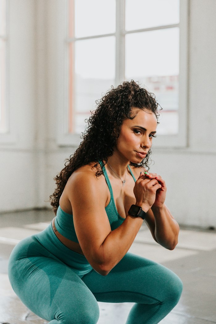 A woman holding a deep squat