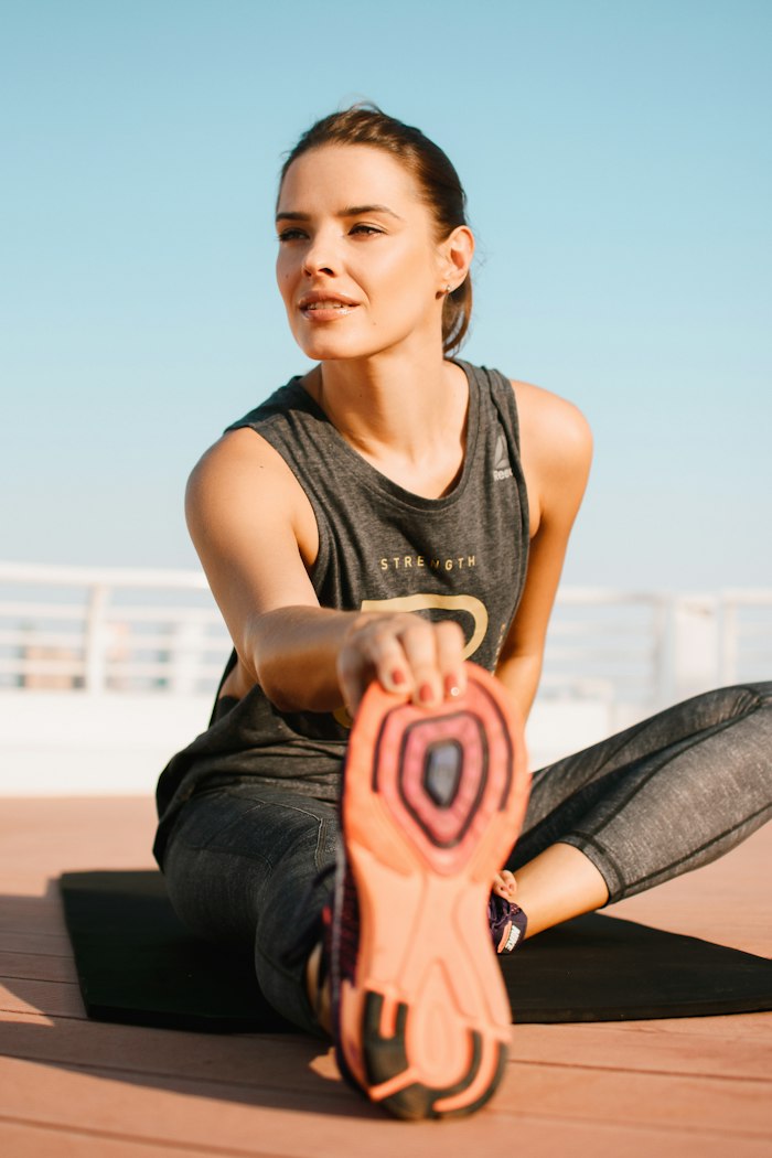 A woman stretching her hamstring on a mat